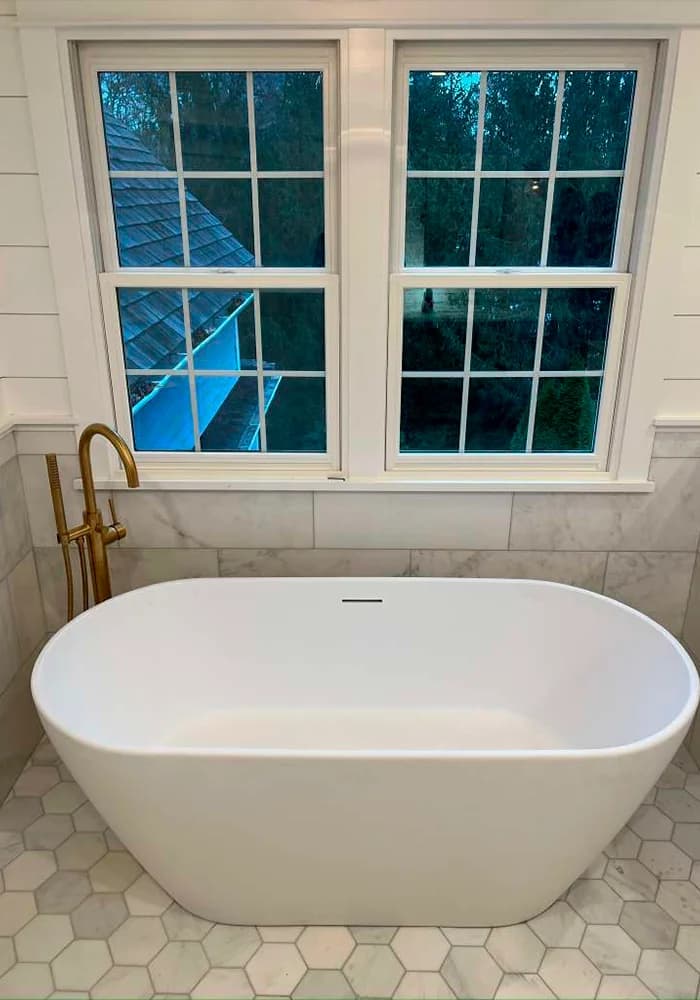 Freestanding bathtub with wall-mounted fixtures